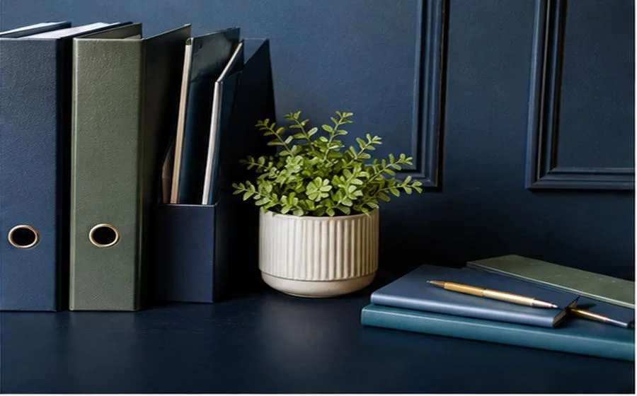 Document folders and a notebook on a desk.